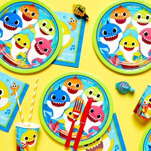 Baby shark party supplies arranged in a styled party setting.