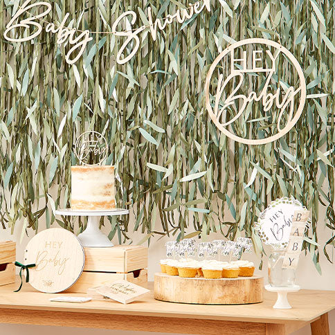 Botanical baby shower supplies arranged in a styled party setting.