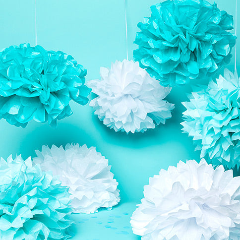 Paper pom poms arranged in a styled party setting.