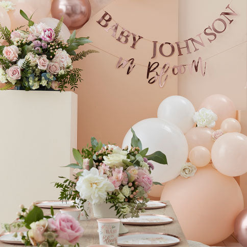 Baby in bloom party supplies arranged in a styled party setting.