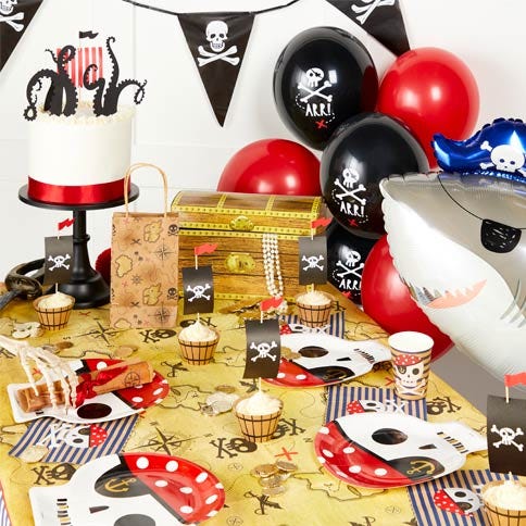 Pirate party supplies arranged in a styled party setting.