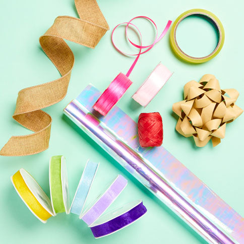 Colourful gift ribbons and bows arranged as a styled wrapping scene.