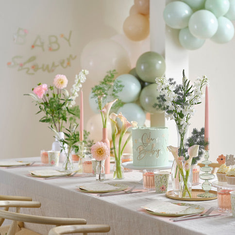 Floral baby party supplies arranged in a styled party setting.