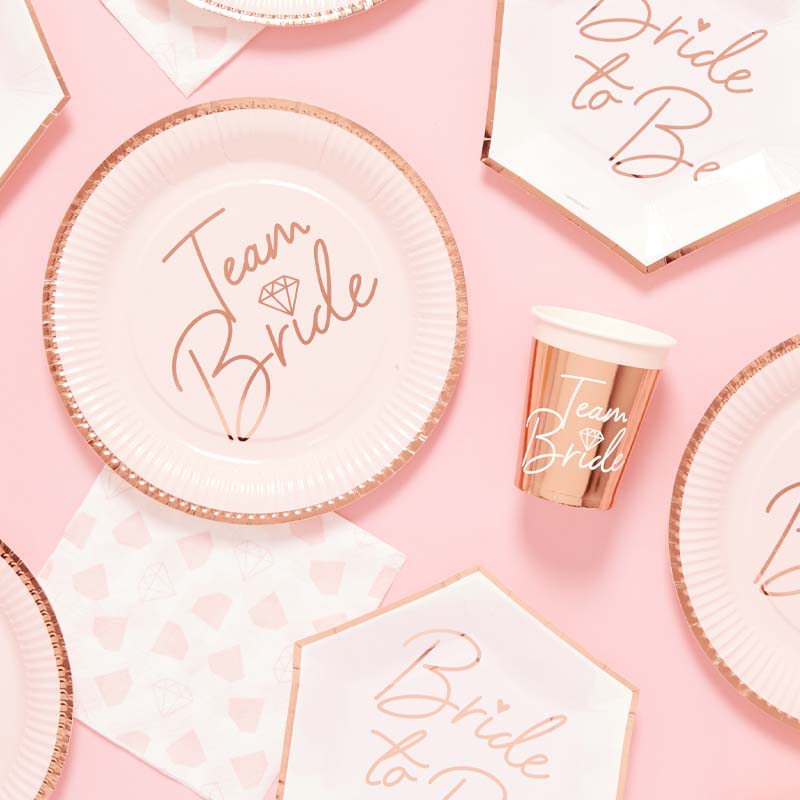 Pink and rose-gold Team Bride plates, cups and Bride to Be napkins for a hen party.