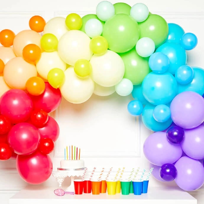 A colourful rainbow balloon arch made with large and small balloons