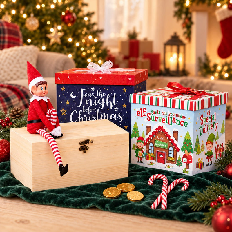 Christmas Eve gift boxes, a wooden chest, an elf doll, chocolate coins and candy canes beside softly lit Christmas greenery.