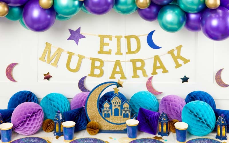 Gold 'Eid Mubarak' banner with blue and purple balloons and lantern
