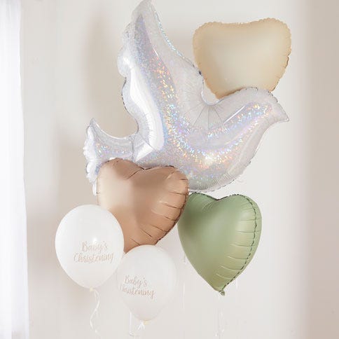 A bunch of christening balloons including three matte heart balloons in neutral shades of cream, blush and sage, two white latex balloons and a shimmering giant white dove balloon all on an off-white background.