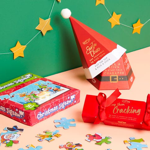 christmas eve games on a table including a jigsaw and charades prompts